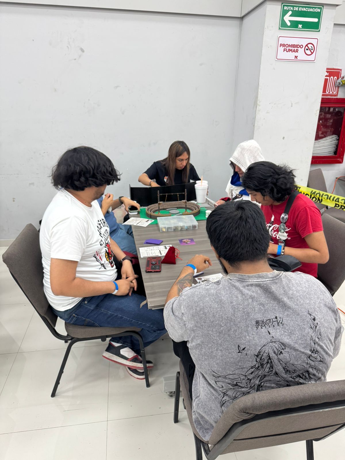 Grupo jugando un one-shot con pantalla de narrador y material sobre la mesa